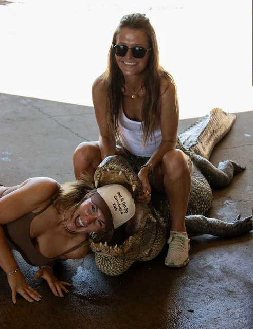 Two customers posing with an alligator inside the barn